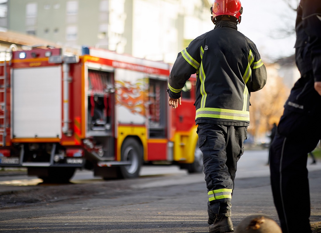 Insurance by Industry - Firemen in Uniform Walking Toward the Front of a Fire Truck Going to Rescue and Protect During an Emergency